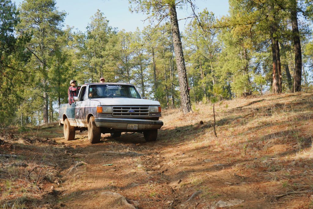 Truck driving down dirt road in Sierra de Tapalpa landscape, Mexico.